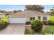 Charming single-story home featuring a well-maintained lawn and attached two-car garage at 13643 Se 89Th Ct, Summerfield, FL 34491