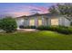 Beautiful exterior view of a home with a manicured lawn taken at dusk at 13643 Se 89Th Ct, Summerfield, FL 34491