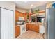 Well-lit kitchen featuring tile floors, wood cabinets, and modern appliances at 13643 Se 89Th Ct, Summerfield, FL 34491