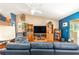 Comfortable living room with hardwood floors, entertainment center, and blue accent wall at 13643 Se 89Th Ct, Summerfield, FL 34491