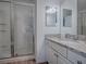 Modern bathroom with a glass-enclosed shower, granite countertop, and stylish white vanity at 1406 Zest Ave, The Villages, FL 32163
