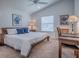 Cozy bedroom featuring a wooden bed frame, soft carpet, and natural light from the window at 1406 Zest Ave, The Villages, FL 32163