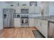 Well-equipped kitchen with stainless steel appliances, white cabinets, and granite countertops, offering a modern and functional space at 1406 Zest Ave, The Villages, FL 32163