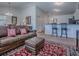 Inviting living room with a comfortable sofa, an ottoman, and bar seating, perfect for relaxing and entertaining guests at 1406 Zest Ave, The Villages, FL 32163
