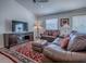 Comfortable living room featuring a large television, plush sofas, and an area rug, creating a cozy atmosphere at 1406 Zest Ave, The Villages, FL 32163