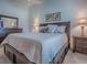 Bright main bedroom featuring a wooden bed frame, a dresser, and bedside tables with lamps at 1406 Zest Ave, The Villages, FL 32163