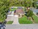 Expansive aerial shot showcasing the home's layout, fenced yard, pool, and surrounding greenery at 15664 Se 97Th Ave, Summerfield, FL 34491