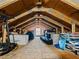 The attic contains wooden beams, storage boxes, and a small window at 15664 Se 97Th Ave, Summerfield, FL 34491