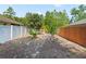 The fenced backyard includes young trees, and the start of a home orchard between the fences at 15664 Se 97Th Ave, Summerfield, FL 34491