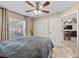 Bedroom features a bed, ceiling fan, a double door closet, and a view into another room at 15664 Se 97Th Ave, Summerfield, FL 34491