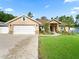 Charming home with a two-car garage, manicured lawn, and elegant landscaping at 15664 Se 97Th Ave, Summerfield, FL 34491