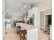 Open kitchen with a center island, granite counters, stainless steel refrigerator, and seamless flow to the living area at 15664 Se 97Th Ave, Summerfield, FL 34491