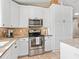Kitchen boasting stainless steel appliances, granite counters, a built-in microwave, and ample white cabinetry for storage at 15664 Se 97Th Ave, Summerfield, FL 34491