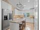 Bright kitchen featuring granite counters, stainless appliances, white cabinetry and a large center island with bar stool seating at 15664 Se 97Th Ave, Summerfield, FL 34491