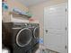 The laundry room features newer machines, shelving, and tile flooring at 15664 Se 97Th Ave, Summerfield, FL 34491