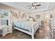 Open main bedroom showcasing tiled floor, a ceiling fan, decorative art, and a doorway to the bathroom at 15664 Se 97Th Ave, Summerfield, FL 34491