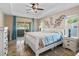 Main bedroom featuring a sliding glass door to a private patio and tray ceiling with decorative metal art at 15664 Se 97Th Ave, Summerfield, FL 34491
