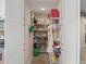 Walk-in pantry featuring tiled floor, ample shelving, and storage space with white double doors at 15664 Se 97Th Ave, Summerfield, FL 34491