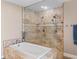 Walk-in shower featuring a rainfall showerhead, tiled walls, and a glass enclosure with a separate faucet at 15664 Se 97Th Ave, Summerfield, FL 34491