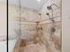 Close-up of a shower featuring a rainfall showerhead, tiled walls, and a built-in shelf at 15664 Se 97Th Ave, Summerfield, FL 34491