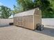 Well-maintained backyard shed with a neutral color scheme and double doors at 15664 Se 97Th Ave, Summerfield, FL 34491