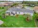 Aerial view showcasing a lush lawn, mature trees, and a patio with outdoor seating, set in a peaceful neighborhood at 17380 Se 111Th Ct, Summerfield, FL 34491
