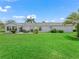The backyard features a lush lawn, mature trees, and patio area ideal for relaxation and entertainment at 17380 Se 111Th Ct, Summerfield, FL 34491