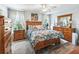 Cozy bedroom with wood flooring, comfortable bed, wooden dresser, and bright natural light at 17380 Se 111Th Ct, Summerfield, FL 34491