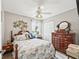 This bedroom showcases a comfortable bed with elegant quilt, a ceiling fan, and classic wood furniture at 17380 Se 111Th Ct, Summerfield, FL 34491