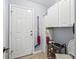 Neutral entryway with tile flooring, white cabinets, shoe racks, and a white exterior door at 17380 Se 111Th Ct, Summerfield, FL 34491