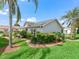 Beautiful single-story home featuring lush landscaping, green grass, and palm trees at 17380 Se 111Th Ct, Summerfield, FL 34491