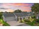 Charming single-story home with lush landscaping, brick driveway, and attached two car garage at 17380 Se 111Th Ct, Summerfield, FL 34491
