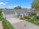 Charming single-story home with manicured landscaping, brick driveway, attached garage, and a welcoming facade at 17380 Se 111Th Ct, Summerfield, FL 34491