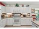 Bright kitchen with white cabinetry, tile backsplash, stainless steel appliances, and ample counter space at 17380 Se 111Th Ct, Summerfield, FL 34491