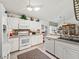 A bright kitchen featuring white cabinetry, tile backsplash, stainless steel appliances and a breakfast bar at 17380 Se 111Th Ct, Summerfield, FL 34491