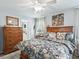 Bedroom featuring a wood-framed bed with a decorative quilt, wooden dressers, and neutral-toned walls at 17380 Se 111Th Ct, Summerfield, FL 34491