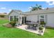 This patio provides a cozy outdoor dining area, complemented by colorful flowers and lush landscaping at 17380 Se 111Th Ct, Summerfield, FL 34491