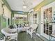 Cozy sunroom featuring wicker furniture, bright decor, and an abundance of natural light at 17380 Se 111Th Ct, Summerfield, FL 34491