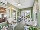 This sunroom offers a relaxing space with wicker furniture, garden views, and plenty of natural light at 17380 Se 111Th Ct, Summerfield, FL 34491