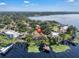 Aerial view of a lakeside property, with a sprawling home, a dock, and serene water views at 1956 Brantley Cir, Clermont, FL 34711