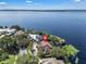 High angle aerial view of a lakeside home featuring a private dock, lush foliage, and sparkling lake waters at 1956 Brantley Cir, Clermont, FL 34711