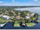 Aerial view of a lakeside property, with a sprawling home, a dock, and serene water views at 1956 Brantley Cir, Clermont, FL 34711