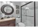 Bathroom with tiled shower, decorative mirror, granite vanity, and a clean, modern aesthetic at 1956 Brantley Cir, Clermont, FL 34711