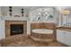 Relaxing bathroom featuring a fireplace next to a soaking tub with tile surround and neutral color palette at 1956 Brantley Cir, Clermont, FL 34711