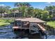 Waterfront boat dock with a covered seating area and a boat lift at 1956 Brantley Cir, Clermont, FL 34711