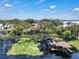 Exterior view showcasing a home with a screened-in pool, lush greenery, and a private dock at 1956 Brantley Cir, Clermont, FL 34711