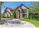 Elegant brick home with arched entryway, manicured landscaping, and a circular brick driveway at 1956 Brantley Cir, Clermont, FL 34711
