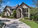 Elegant brick home with arched entryway, manicured landscaping, and a circular brick driveway at 1956 Brantley Cir, Clermont, FL 34711