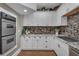 Updated kitchen features custom cabinetry, granite countertops, and stainless steel appliances at 1956 Brantley Cir, Clermont, FL 34711