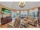 Cozy living room features large windows offering beautiful water views, hardwood flooring and comfortable seating at 1956 Brantley Cir, Clermont, FL 34711